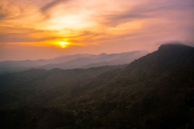 Scenic view of mountains against orange sky