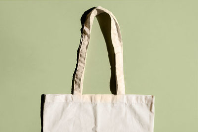 Reusable cotton shopping bag on green and beige background. zero waste concept. no plastic