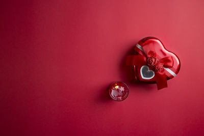 High angle view of ring on pink table against red background