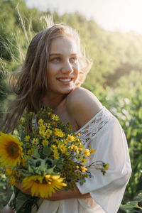 Portrait of smiling young woman against blue sky