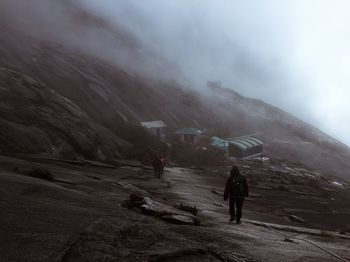 People walking on mountain against sky