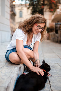 Woman with dog sitting outdoors