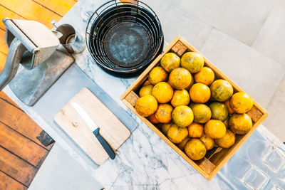 High angle view of fruits in crate by container on table