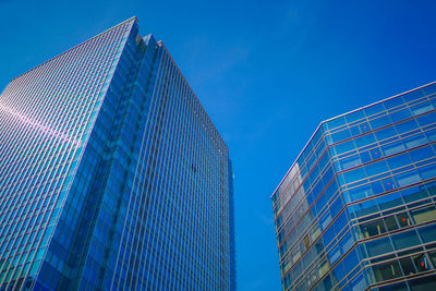 Low angle view of modern building against blue sky