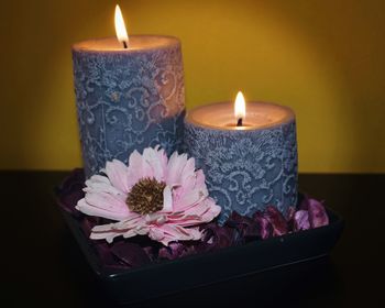 Close-up of lit candle on table