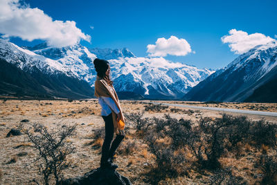 Man standing on snowcapped mountain against sky