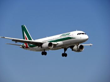 Low angle view of airplane against clear blue sky