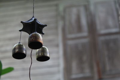 Low angle view of electric lamp hanging against wall