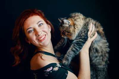 Portrait of smiling young woman with cat