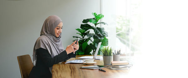 Young woman using laptop while sitting at home