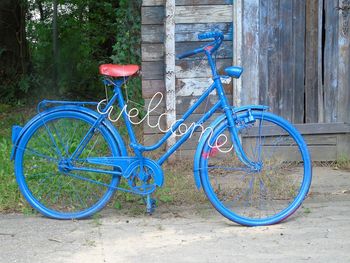 Blue bicycle with welcome sign on road