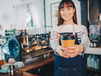 Portrait of woman holding coffee cup