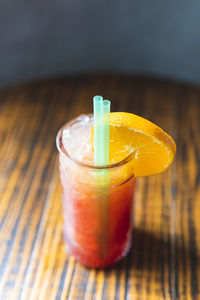 Cocktail glass with straw on table at bar