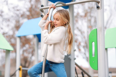 Girl hanging on metal in playground