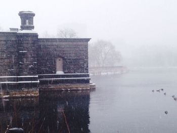 Reflection of building in lake during winter