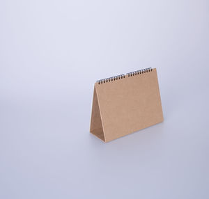 High angle view of blank brown desk calendar on white background