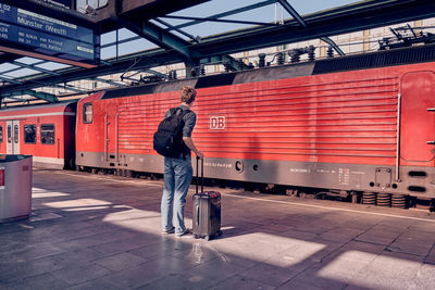 Rear view of man standing at railroad station