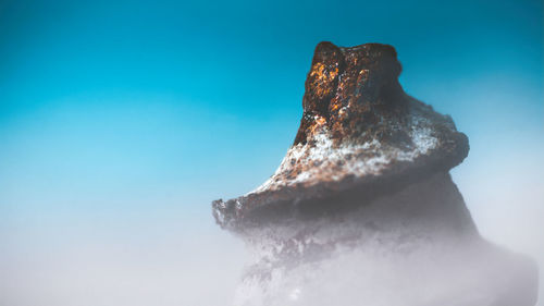 Close-up of blue sea against sky during winter