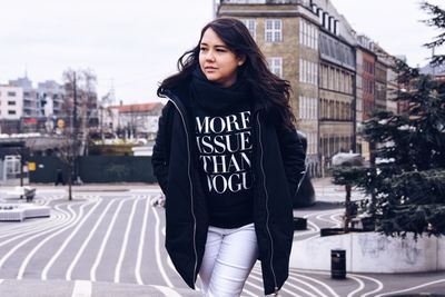 Portrait of beautiful woman standing in city