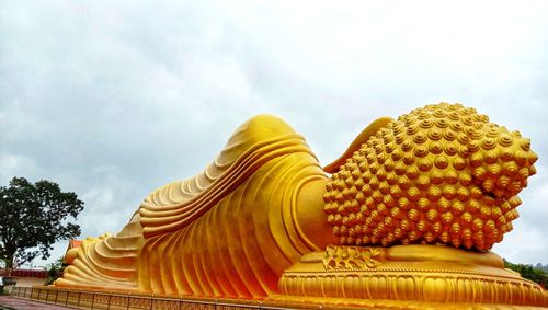 Low angle view of statue against temple against sky