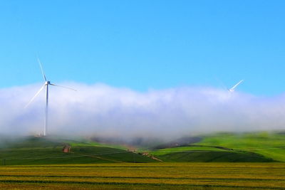 Windmill on field against sky