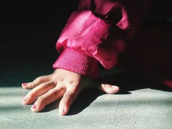 Low section of woman with pink petals on floor