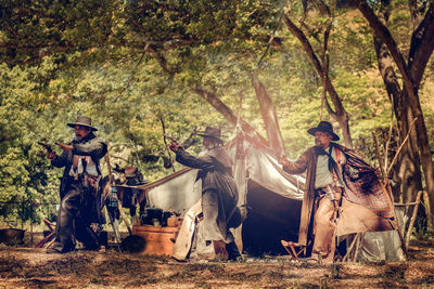 Men aiming guns in forest