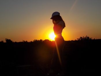 Silhouette man standing against sky during sunset