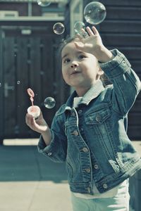 Full length of boy standing at bubbles