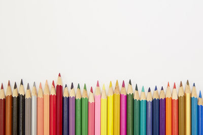 Close-up of multi colored pencils against white background