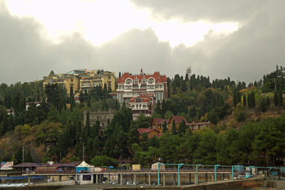 Buildings in city against cloudy sky