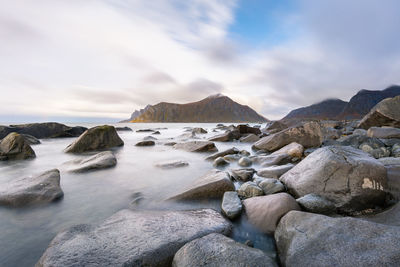 Rocks on sea shore against sky