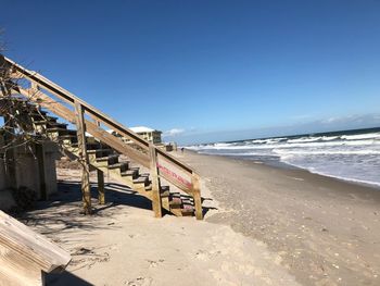 Scenic view of beach against clear blue sky