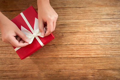 High angle view of hand holding paper on table