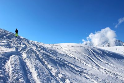 Low angle view of snowcapped mountain against blue sky