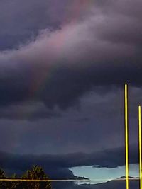 Scenic view of rainbow over sea against dramatic sky