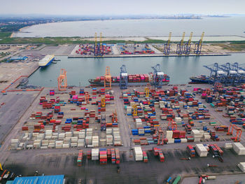 Aerial view of commercial dock by sea against sky