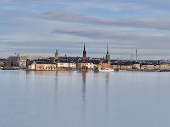 River amidst buildings in city against sky