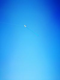 Low angle view of vapor trail against clear blue sky