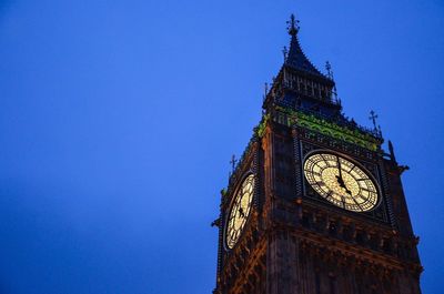 Low angle view of clock tower against blue sky