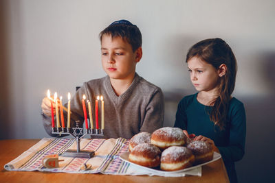 Boy looking away while standing on cake