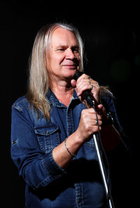 Midsection of woman holding umbrella against black background