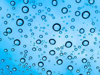 Close-up of water drops on blue glass