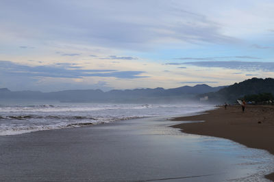 View of beach against cloudy sky