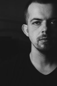 Close-up portrait of young man against black background