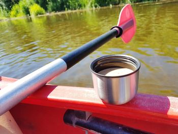 Close-up of tea light by railing in lake