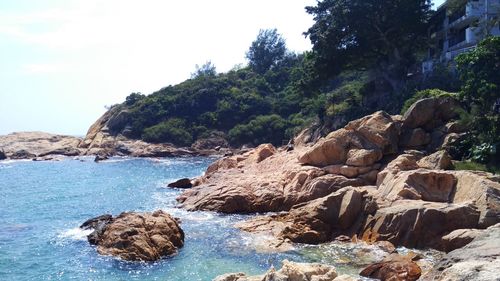 Scenic view of river by rock formations against sky on sunny day