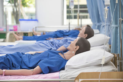 Mannequins on beds in hospital ward