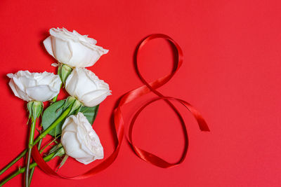 Greeting card for women's day march 8, number eight from red ribbons, bouquet