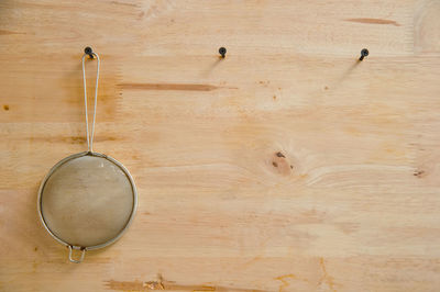 Strainer hanging on nail mounted on wood